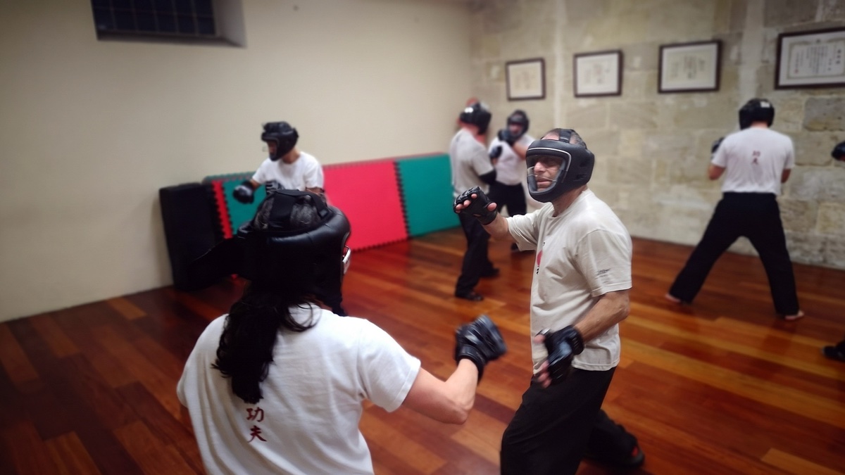 Deux pratiquants de Wing Chun en situation de combat, cherchant l'angle et l'ouverture.